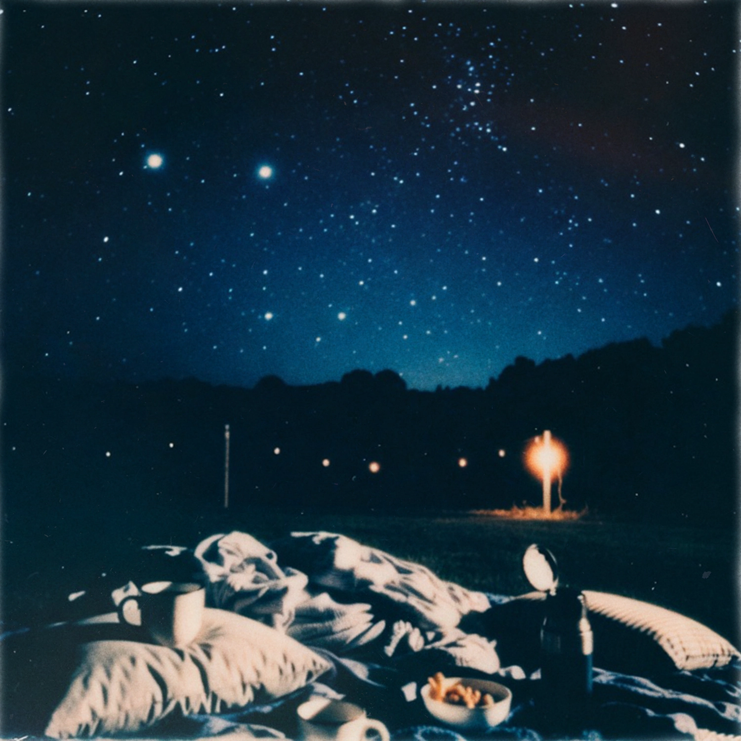 Blankets and snacks laid out under a night sky